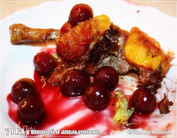 Выкладываем кусок утки на тарелку. Сверху апельсины и соус с вишнями.