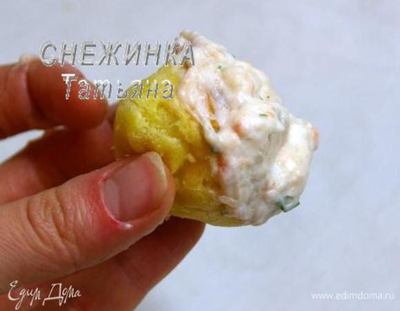 Теперь будем укладывать профитроли в конус, промазывая их щедро кремом. На что обратить внимание! Во-первых, профитроли нужно укладывать лицевой стороной в стороны, чтобы, когда снимем конус, на нас смотрел верх профитролей, а не та часть, на которой они пеклись. Во-вторых, первый «шарик» кладём верхней частью вниз конуса, это потом будет наша верхушка. В-третьих, при закладывании профитролей, промазываем только те части, которыми мы будем соединять их между собой, а это нижняя часть и немного с боков. 

