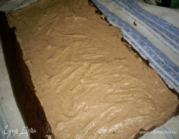 Охлажденный бисквит разворачиваем, смазываем кремом (без какао) и снова скручиваем рулетом.