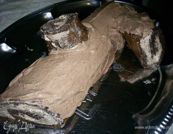 Обмазываем рулет шоколадным кремом, приклеиваем к рулету отрезанные кусочки. Их предварительно можно немного уменьшить.