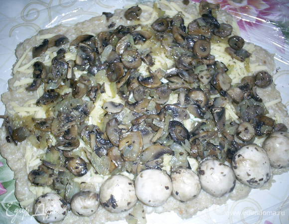 Посыпаем тертым сыром. Сверху не доходя по 1,5 см до краев выкладываем остывшую начинку. С помощью пленки или бумаги аккуратно сворачиваем рулет и защипываем края.Из такого количества фарша получается два небольших рулета.