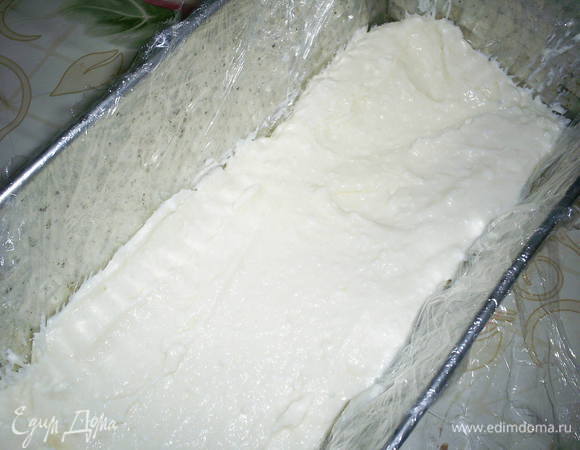 Форму, в которой будем собирать десерт, выстилаем пищевой пленкой. Выкладываем меньше половины творожной массы, сверху вишни.