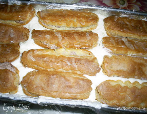 Выкладываем сверху оставшуюся творожную массу и разравниваем. На этом можно и остановится, но мне хотелось большего. Сверху можно было бы выложить печенье Савоярди или, на худой конец, просто бисквит.За неимением ни первого, ни второго и ленью их готовить я выложила готовые 12 эклеров с кремом. Отправляем в холодильник часов на 5, лучше на ночь.