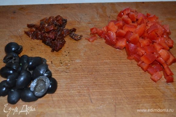 Перец и вяленые томаты нарезаем небольшим кубиком. Оливки разрезаем пополам. Каперсы и анчоусы мелко рубим.