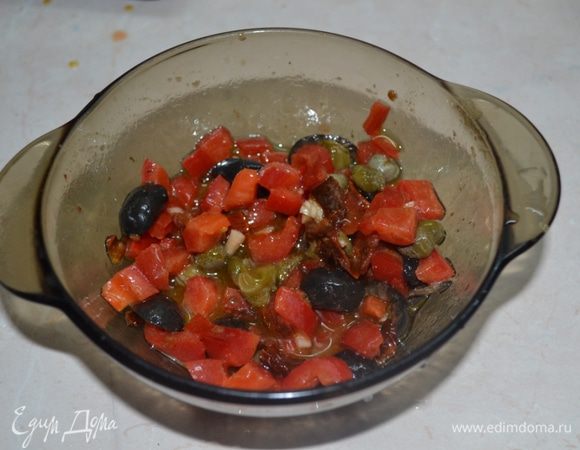 В посуде соединяем оливковое масло, французскую горчицу, сок лимона, молотый перец, соль, сахар и пропущенный через пресс чеснок. Добавляем оливки, перец, каперсы и анчоусы, перемешиваем.