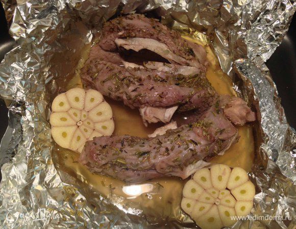 Чеснок вымыть, обсушить и разрезать  поперек на 2 части. Из духовки достать форму с мясом, развернуть фольгу, выложить к мясу чеснок и вернуть в духовку под гриль,  увеличив температуру до 200-220 градусов минут на 12.