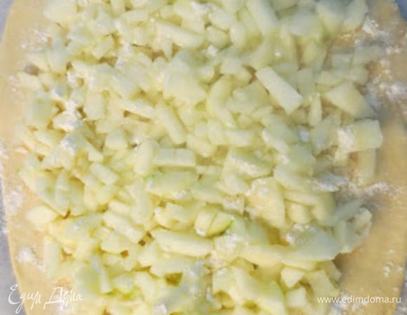 Для начинки, яблоки очищаем от кожуры, режим на маленькие кусочки, смешиваем с сахаром и сбрызгиваем лимонным соком, перемешиваем. После того как начинка готова, распределяем ее равномерным слоем на нижней лепешке.