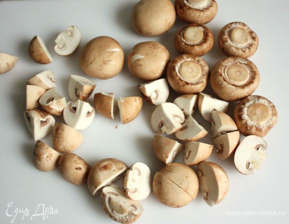 Кусочки сырого бекона разрезать пополам вдоль, обжарить в сковороде на среднем огне, переворачивая один раз.
Очищенные грибы нарезать половинками или четвертинками и обжарить с 20 г сливочного масла.
