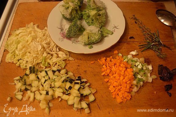 Почистить морковь. Если необходимо удалить из цуккини семена. Порезать мелким кубиком морковь и цуккини. Вымыть, порезать лук. Достать из морозилки брокколи. Приготовить базилик-мелко порезать. С тимьяна оборвать листочки.