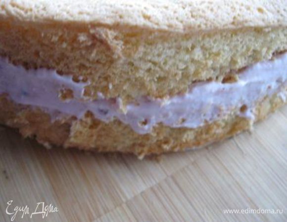 Разрезать бисквит на 2 части, нижний корж промазать кремом с брусникой.

