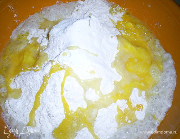 В миску с подошедшей опарой просеять муку, добавить растопленное масло, растертые с остальным сахаром желтки, соль и ванилин.