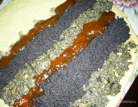 На тесто полосками, не доходя по 2 см до краев, выкладываем начинки: сначала ореховую, затем мак и джем. Так повторяем до половины коржа. 