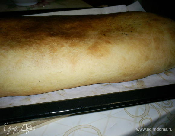 Аккуратно сворачиваем тесто в рулет. Если начинки положить больше, чем до половины коржа (как у меня на фото), это сделать будет довольно сложно. Так что не переборщите  с начинкой. Края рулета защипываем. Кладем рулет на противень с бумагой, смазанный маслом. Я ставила его в холодную духовку и сразу включила ее на температуру 200 градусов. Выпекаем примерно час на средней полке. Следите, чтоб рулет не подгорел.