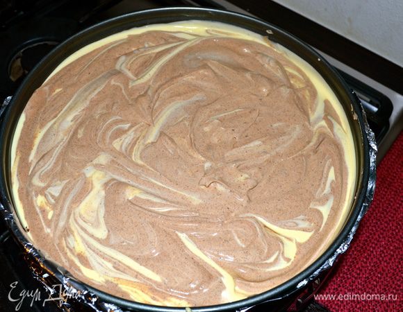 Выложить белую начинку на корж, сверху положить шоколадную начинку и вилкой сделать завитки. 