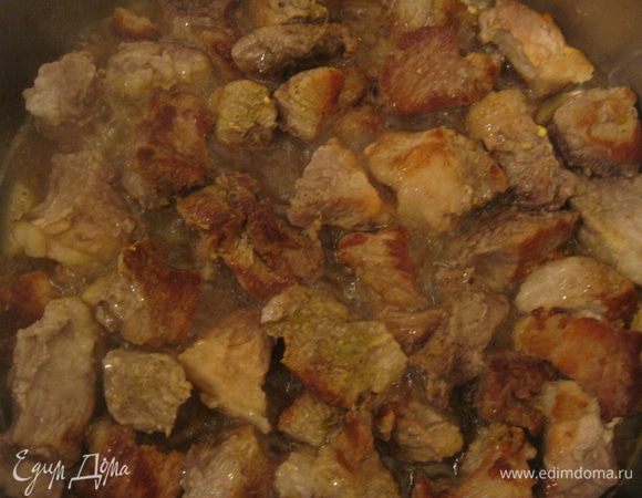 Мясо порезать на кусочки. Разогреть оливковое масло в большой тяжёлой сковороде и обжарить кусочки мяса 5-10 минут со всех сторон, пока они не подрумянятся. 