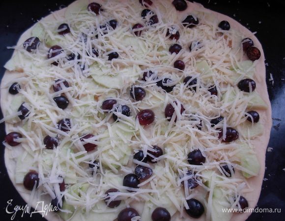 Выкладываем начинку, дольки яблок, виноград. Сверху посыпаем тертым сыром.
Ставим в разогретую до 200°С. духовку на 10-15 мин. 