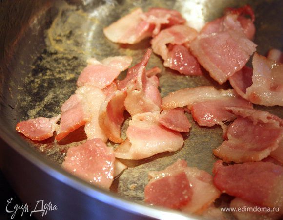 Для спагетти поставить воду кипятиться в кастрюле. 
Тем временем в большой сковороде жарить ломтики бекона на среднем огне, периодически помешивая, до состояния золотистой корочки либо около того.
