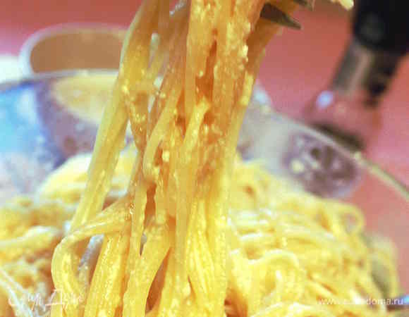Приготовленные спагетти опрокинуть на дуршлаг ненадолго, чтобы осталось немного влаги. Затем очень быстро перенести  спагетти к смеси из яиц, сыра, молока со сливками. Добавить бекон, поперчить и все аккуратно перемешать. 