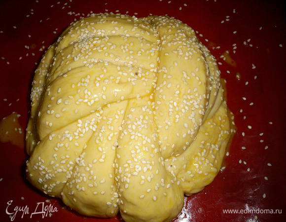 Перекладываем нашу плетенку на противень с бумагой и даем постоять минут тридцать. Затем смазываем взбитым яйцом и посыпаем кунжутом. Выпекаем в разогретой до двухсот градусов духовке примерно 40 минут. Плетенка должна зарумяниться, но не сгореть.