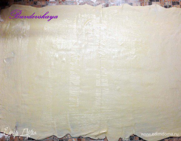 Тесто разморозить при комнатной температуре (15–20 минут). Посыпать рабочую поверхность мукой и раскатать тесто скалкой в очень тонкий пласт. Растопить сливочное масло и смазать им раскатанное тесто.