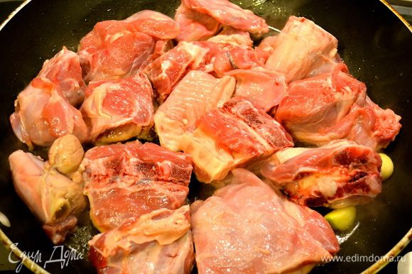 Духовку включить на 200°С. В глубокой тяжелой сковороде разогреть оливковое масло и жир. Положить чеснок и розмарин. Добавить мясо.