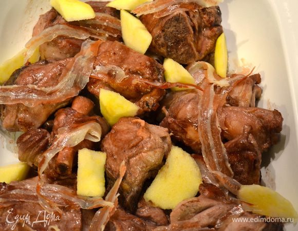 Переложить кусочки мяса в форму, которую можно поставить в духовку. Полить образовавшимся соусом со сковороды. Выложить на козлика полосочки бекона и положить в свободном порядке кусочки яблока. Поставить форму в духовку на нижний уровень (чтобы мясо слишком не подсохло сверху). 