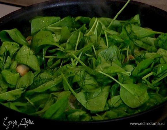 Добавить зеленый лук и шпинат, еще немного обжарить, затем уменьшить огонь и готовить 2–3 минуты, чтобы шпинат стал мягким.