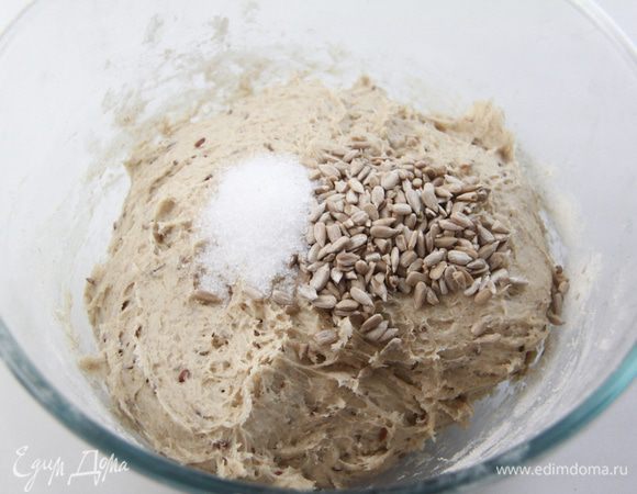Добавить соль и семена подсолнечника, вымешивать тесто минут 10.