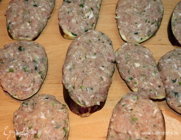 Баклажаны вымыть и порезать на круглые кусочки.  Посолить каждый кусочек, дать полежать 5 минут и промыть под  водой. Равномерно накладываем фарш на каждый кусочек баклажана.