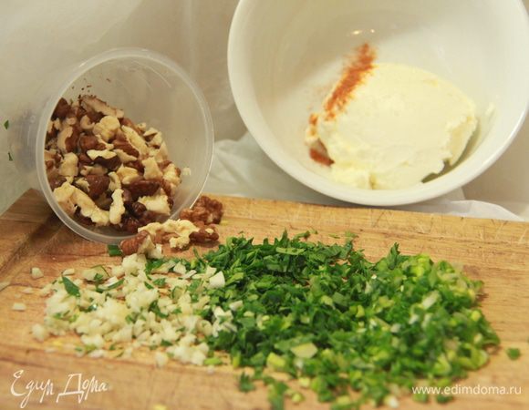 Подготовить ингредиенты для начинки: орехи, чеснок и зелень мелко порубить, в сливочный сыр добавить соль, перец чёрный и кайенский.