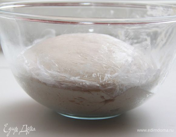 Добавить 15 г соли, работать с тестом ещё 5-7 минут, пока тесто не станет эластичным и не перестанет липнуть. Убрать тесто под плёнку в тёплое место на 1 час.