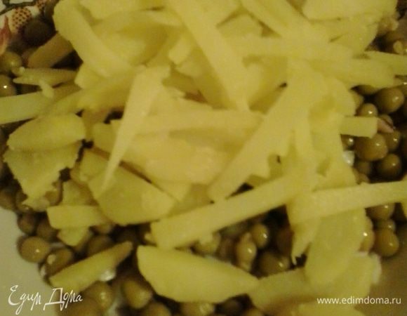 В салатник с луком и кальмарами добавляем горошек и нарезанный соломкой картофель.