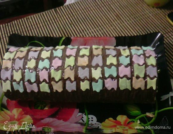 Сверху смазать шоколадом, растопленным на водяной бане и выложить мастикой в виде пазлов.