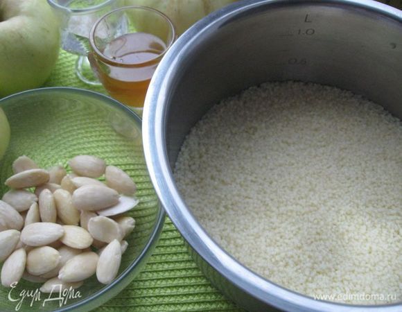 Миндаль залить кипятком на 5 минут. Слить воду, очистить от шелухи. Измельчить, разделить на 2 части. Большая будет использована в начинке, меньшая - для посыпки готового блюда. Кокосовую стружку измельчить. Изюм порезать. Кус-кус залить кипятком (1 стакан) и дать настояться 15 минут.