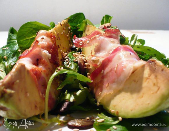 Выкладываем салат горкой, а на неё кусочки авокадо. Посыпаем кунжутом и тыквенными семечками.