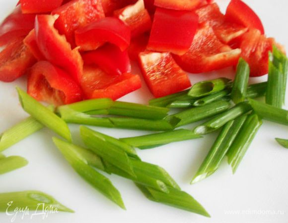  Красный перец  помыть, очистить от семян и нарезать кусочками. 
Стебли лука нарезать поперёк по 2 см. 