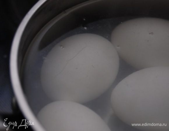 5 яиц поместить в подходящую емкость, залить холодной водой, добавить 1 ст.л. соли (соль на тот случай - если вдруг в яйце есть трещина. Знаете как бывает, когда вместо яйца в кострюльке убежавший вареный белок.... Соль не позволит белку покинуть пределы яйца)))). На среднем огне довести до кипения, проварить ровно 1 минуту, снть с огня и оставить в кипятке еще на 3 минуты. Слить горячую воду, залить холодной.  Остудить. Очистить от скорлупы.
