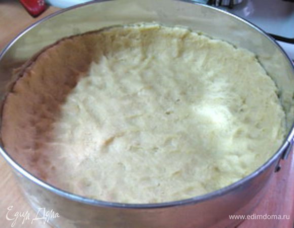 Охлажденное тесто выложить в разъемную форму диаметром 26 см и равномерно распределить тонким слоем по всей площади, подняв бортик на 2,5-3 см.