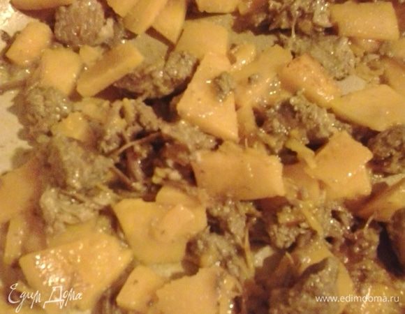 К тыкве добавляем тушенку и еще немного обжариваем.