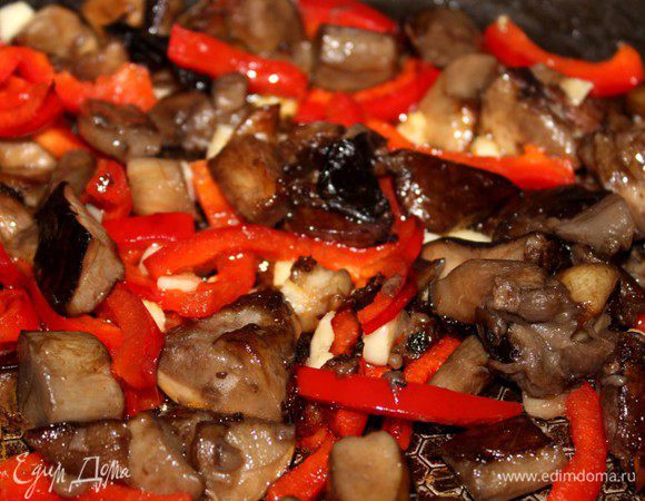 Грибы разморозить, слить воду и обжарить на оливковом масле с нарезанным болгарским перцем и чесноком в течение 7-10 минут.