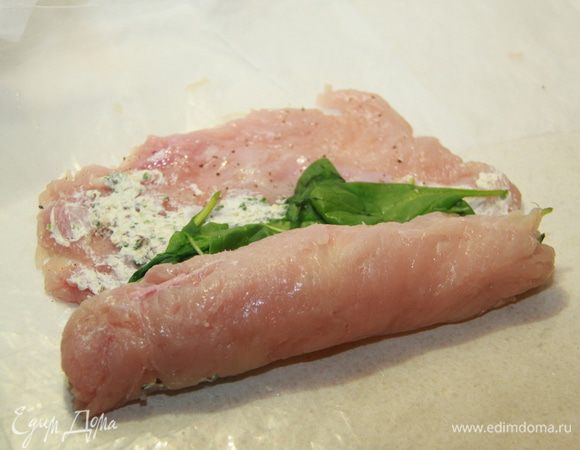 Листья базилика обсушить бумажным полотенцем и выложить поверх начинки. Завернуть мясо рулетом.