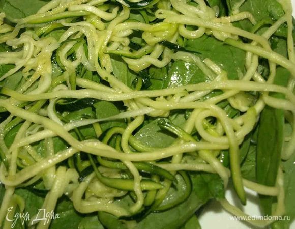 Выкладываем на тарелки шпинат (половину), сверху маринованную лапшу из цукини (или полоски)