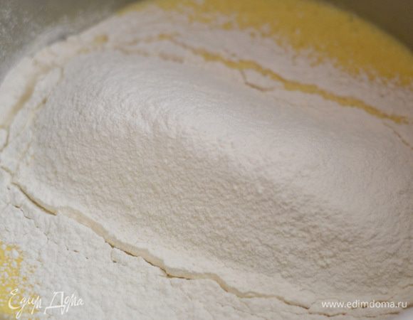 Просейте муку с разрыхлителем, включите миксер и перемешайте на минимальной скорости до однородности.