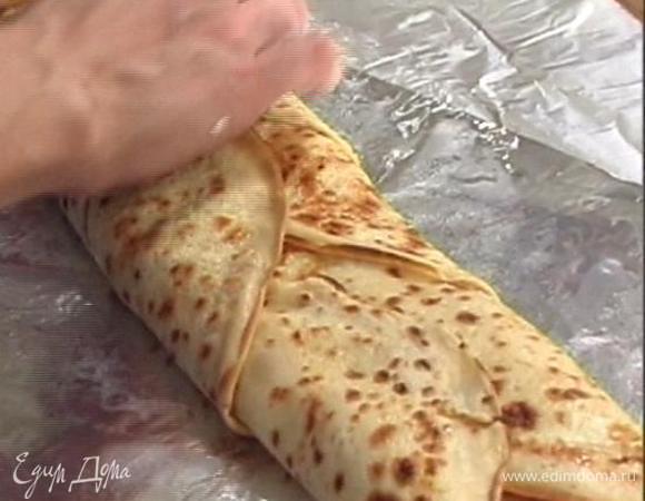 На сложенной в два слоя фольге разложить блины внахлест друг на друга, сверху выложить замаринованную семгу, полить ее сметанным соусом, посыпать сыром и свернуть в рулет, затем завернуть все в фольгу и отправить на час в холодильник.