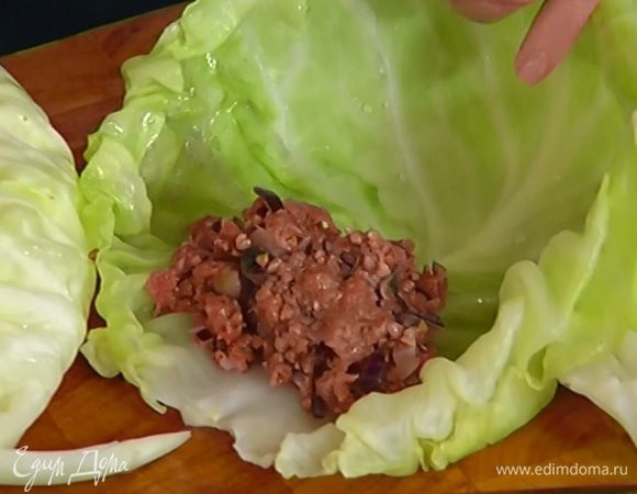Просушить 7–8 капустных листьев бумажным полотенцем, срезать грубые черенки, на край каждого листа выложить немного начинки и свернуть конвертиком.