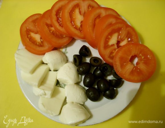 Помидоры нарезать кружочками, маслины - пополам, моцареллу - толстыми ломтиками.