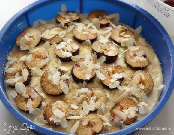 Из слив удалите косточки, выложите мякоть на тесто, посыпьте миндальными лепестками и тростниковым сахаром. Выпекайте в разогретой духовке при 200°C 30–40 минут.