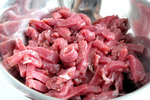 Мясо порезать тонкими полосками, положить в миску и полить соевым соусом. Оставить.