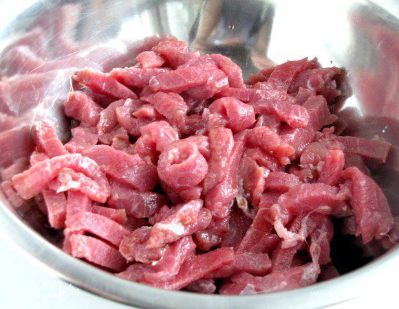 Мясо порезать тонкими полосками, положить в миску и полить соевым соусом. Оставить.