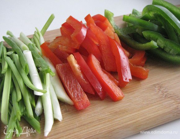 Перцы промыть, удалить семена и нарезать полосками шириной 0,5 см. Зеленый лук нарезать кусочками длиной 5 см.